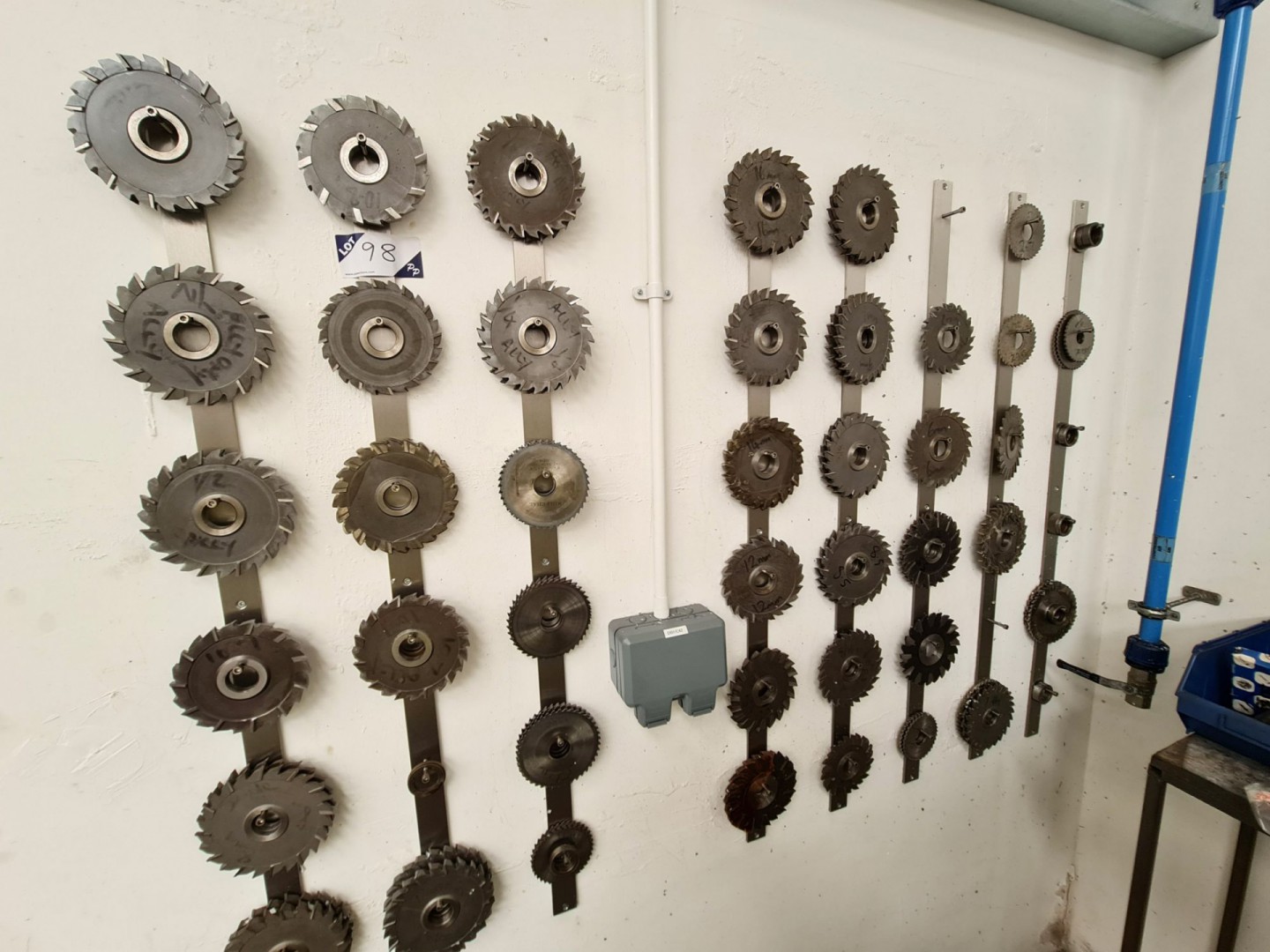 Qty various milling cutters on wall mounted storag...